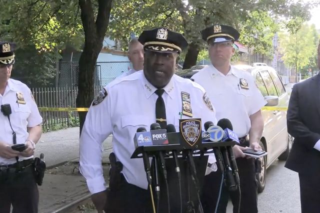 A screenshot of a police press conference where NYPD Chief of Patrol Jeffrey Maddrey asks the public's help in finding a shooter who killed a 14-year-old boy
